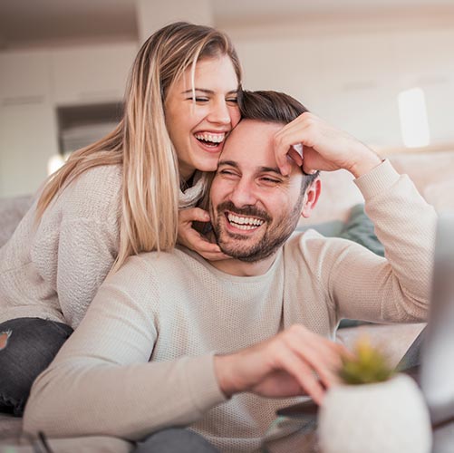 couple at home laughing after gum grafting treatment