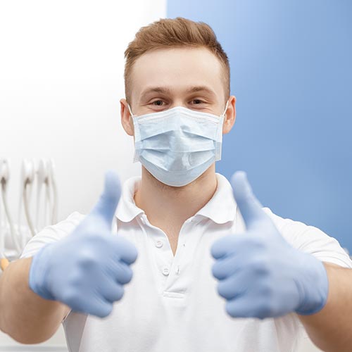 dentist with mask showing thumbs up